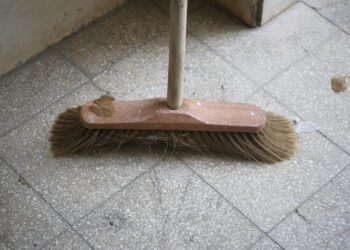 Wooden indoor broom in the stairway entrance of an apartments house.