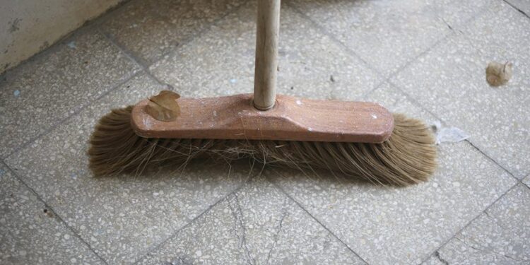 Wooden indoor broom in the stairway entrance of an apartments house.