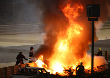 Fire marshals put out a fire on Haas F1's French driver Romain Grosjean's car during the Bahrain Formula One Grand Prix at the Bahrain International Circuit in the city of Sakhir on November 29, 2020. (Photo by Bryn Lennon / POOL / AFP)