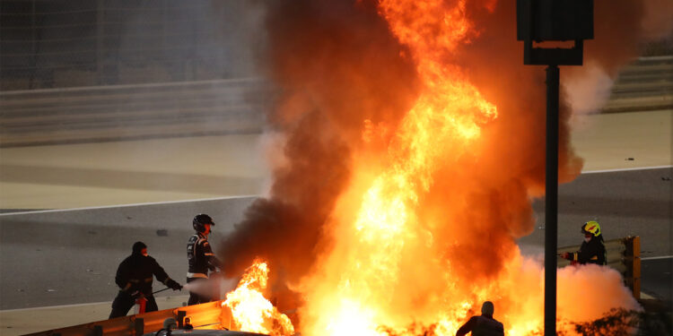 Fire marshals put out a fire on Haas F1's French driver Romain Grosjean's car during the Bahrain Formula One Grand Prix at the Bahrain International Circuit in the city of Sakhir on November 29, 2020. (Photo by Bryn Lennon / POOL / AFP)