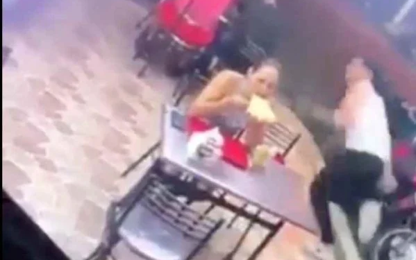 Mulher parece não se abalar com a ação da dupla e continua comendo tranquilamente seu 'kikão'. Foto: ReproduçãoYouTube