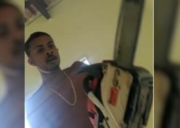 Homem usa uma motoserra para ameaçar um jovem. Foto: Reprodução