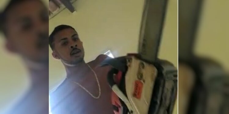 Homem usa uma motoserra para ameaçar um jovem. Foto: Reprodução