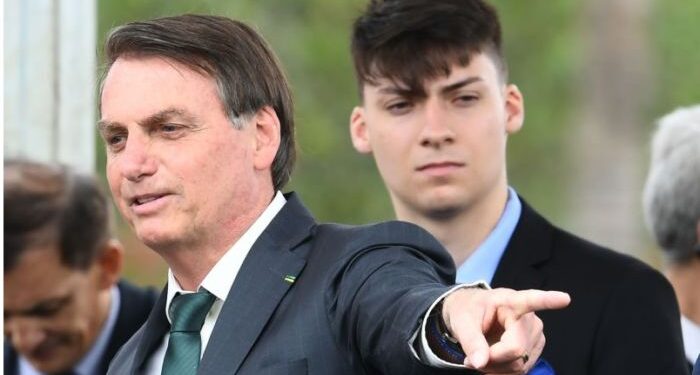 Brazilian President Jair Bolsonaro (R) gestures next to his son Jair Renan Bolsonaro, during the launch of his new party, the Alliance for Brazil, at a hotel in Brasilia on November 20, 2019.  Bolsonaro left the Social Liberal Party after a disagreement with the party president Luciano Bivar. / AFP / EVARISTO SA