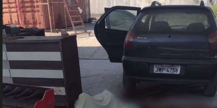 O corpo estava estirado ao lado do carro do vigia. Foto: Divulgação