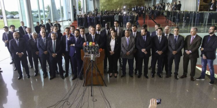 Presidente Jair Bolsonaro, acompanhado de vários ministros, fala com a imprensa no Palácio da Alvorada