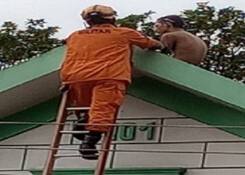 O homem ficou horas em cima do telhado até desistir e descer com o bombeiro. Foto: Reprodução