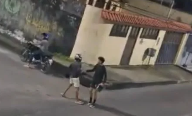 O garupa desce, anuncia o roubo e pega o celular do rapaz. Foto: Reprodução